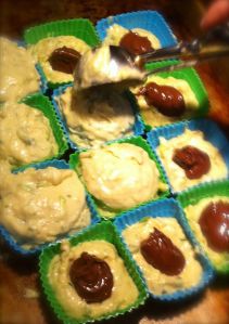 Action shot of me covering the muffins with the rest of the batter.