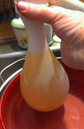 Filling up Mr. Yellow, with a red bowl underneath, ready to catch the balloon.